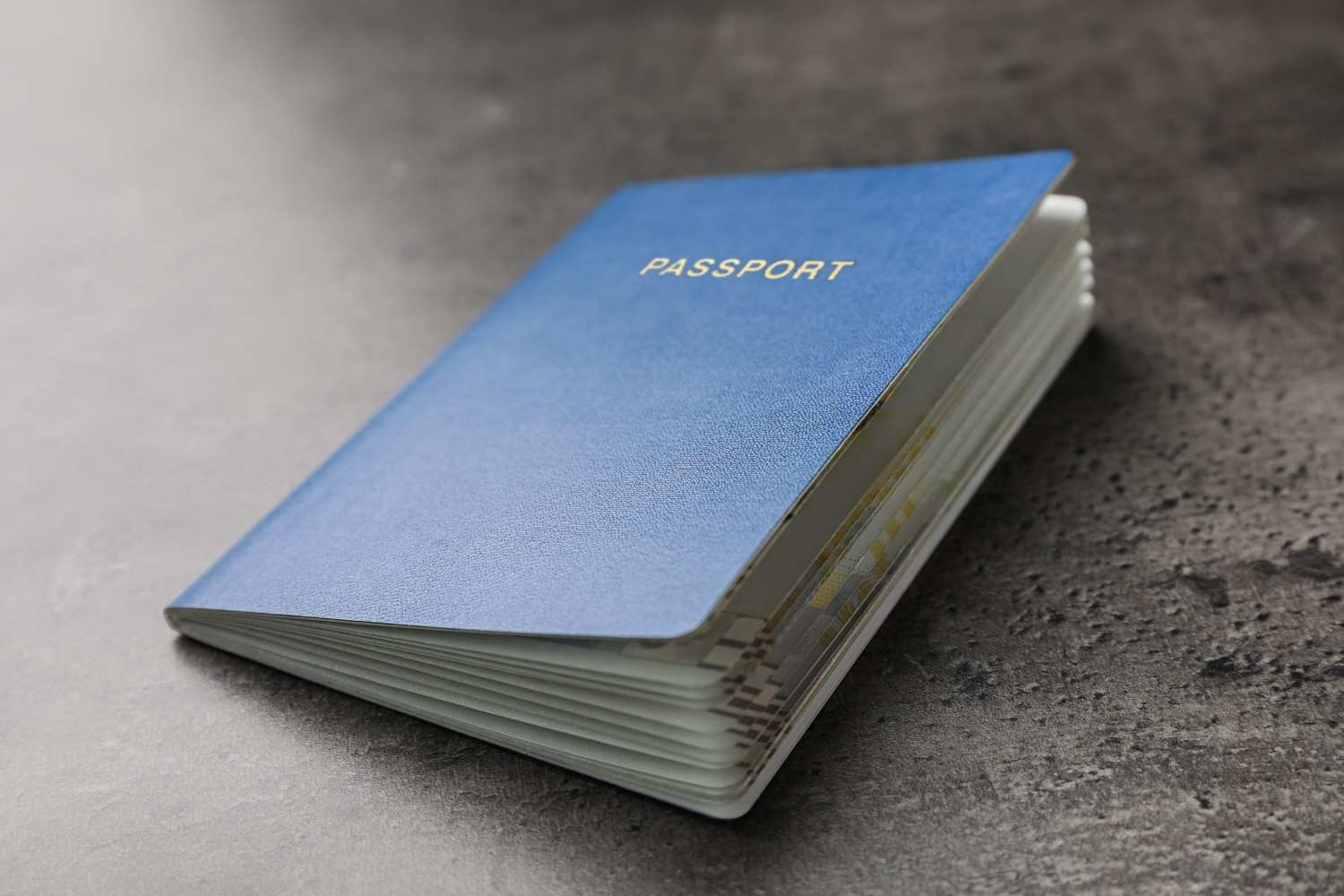 A Blue Passport On A Black And Grey Table