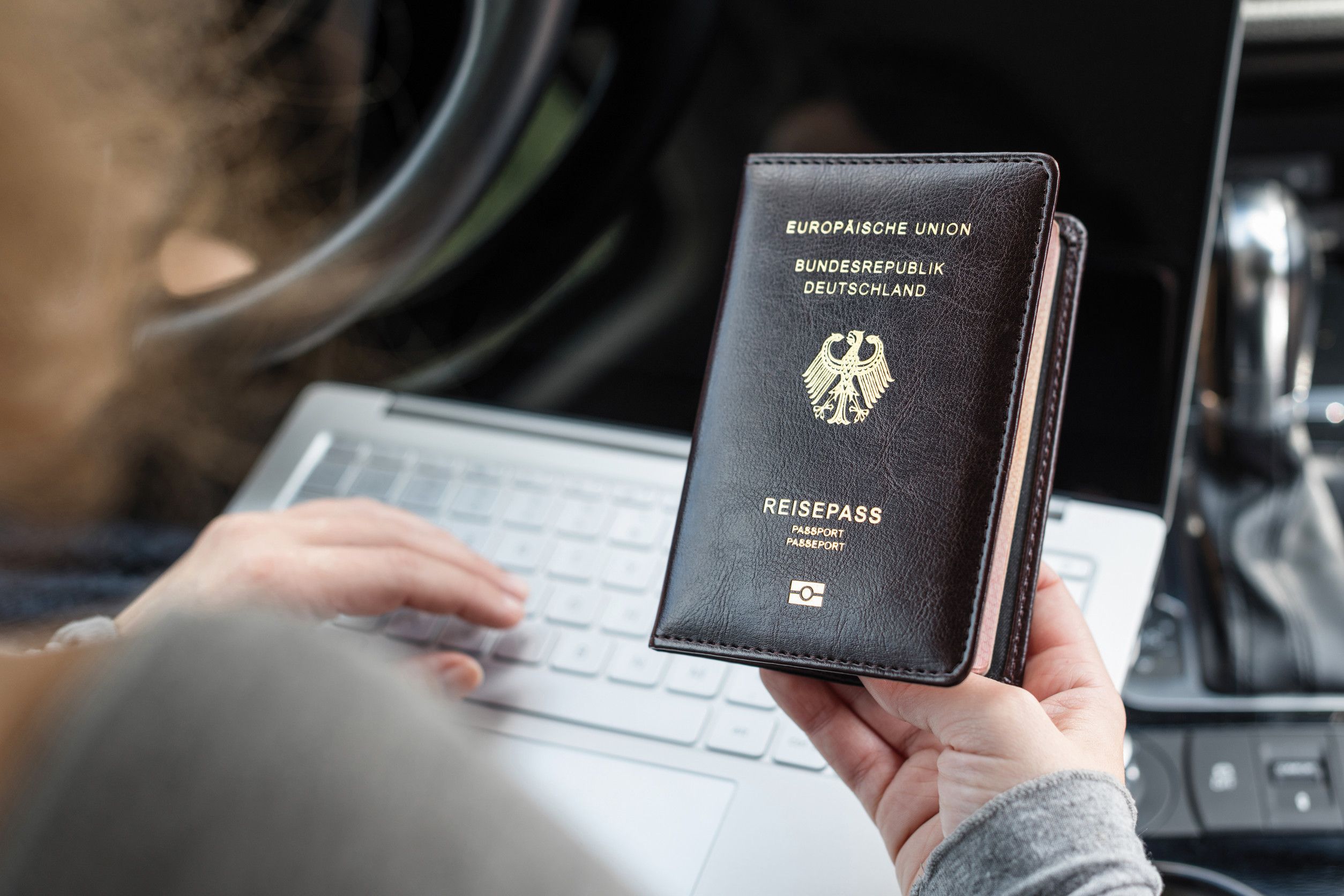 Woman In The Car With Laptop And Germany Passport Business Concept